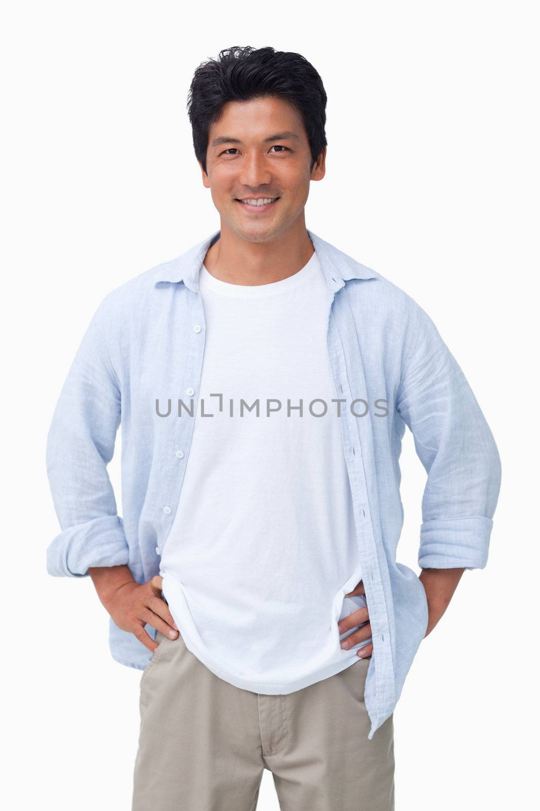 Smiling male with hands on his hip against a white background
