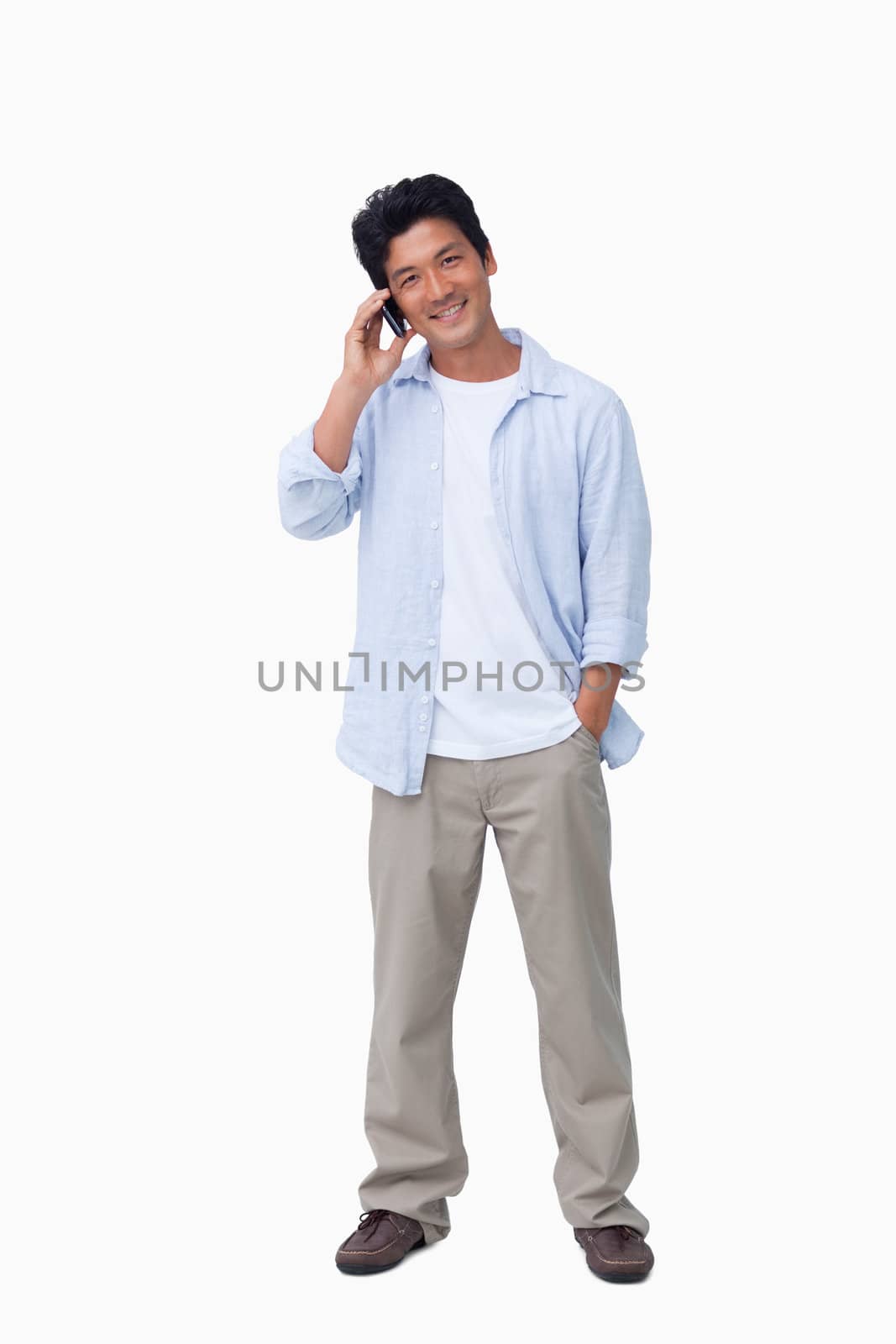 Smiling male on cellphone against a white background