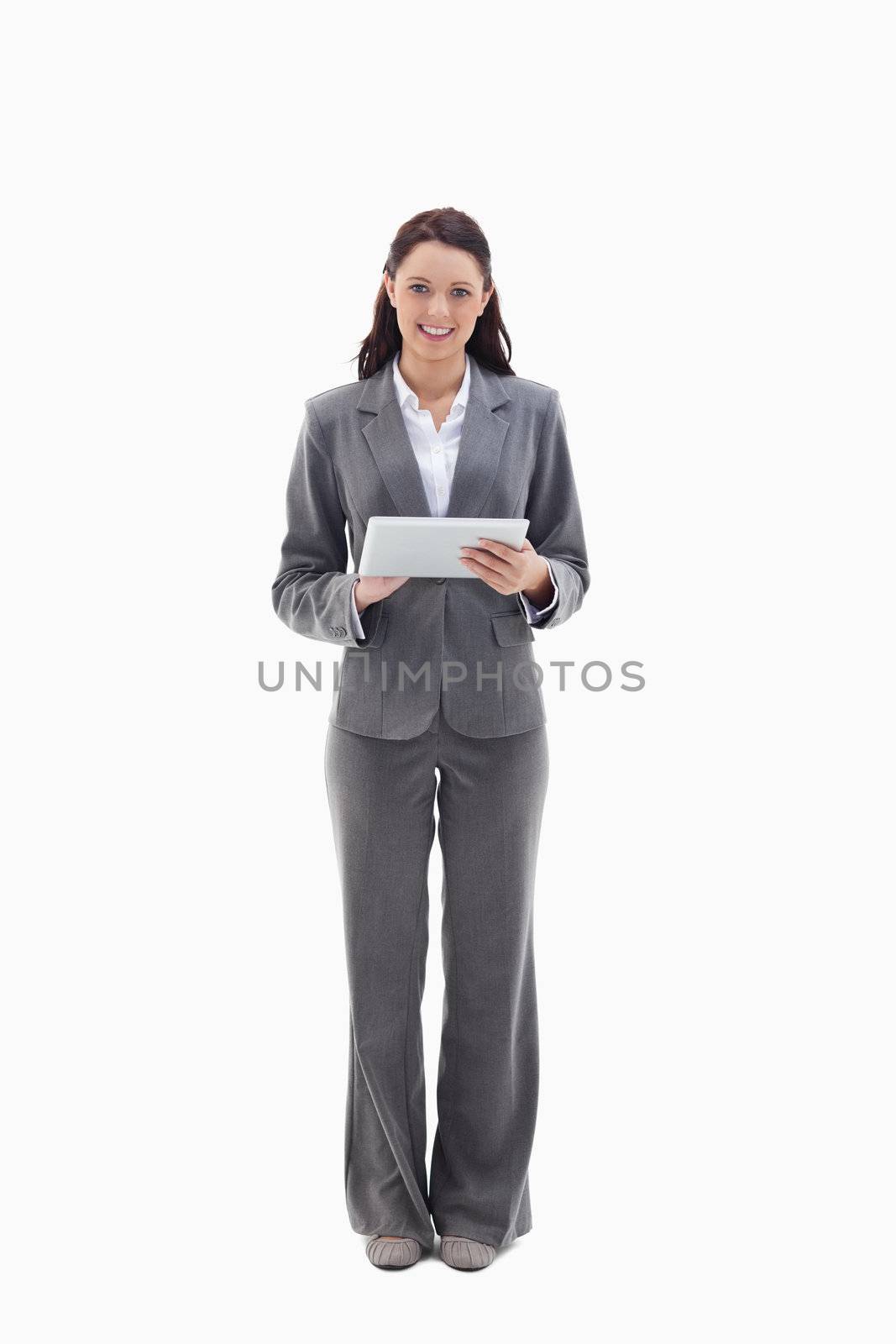Businesswoman smiling with a touch pad against white background