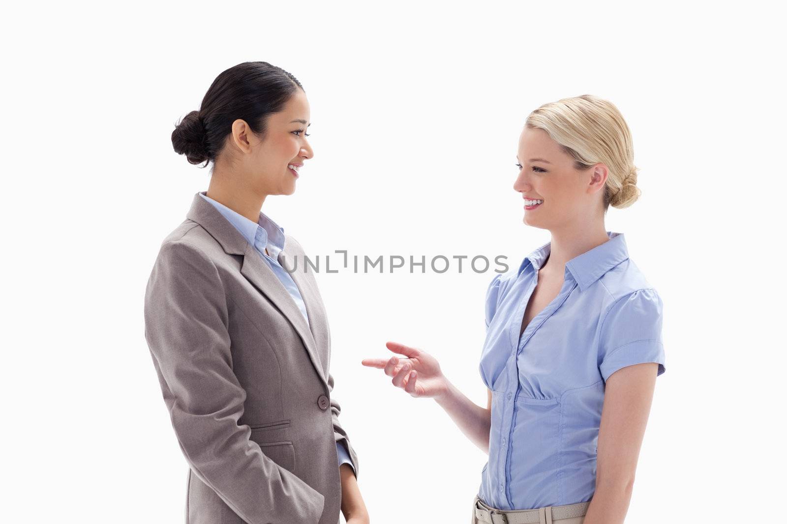 Two women talking happily against white background