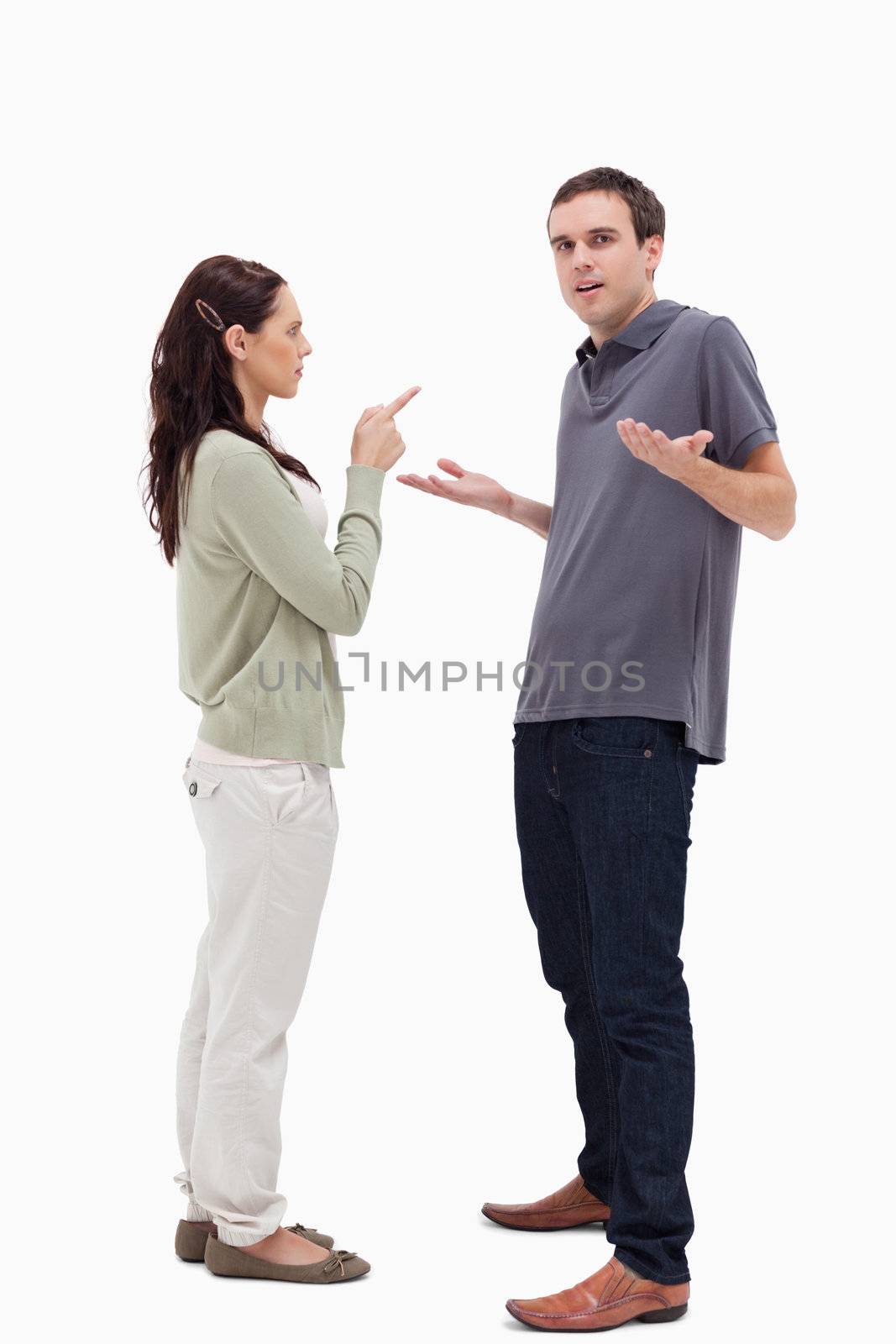 Man shrugged his shoulders is scolded by woman against white background