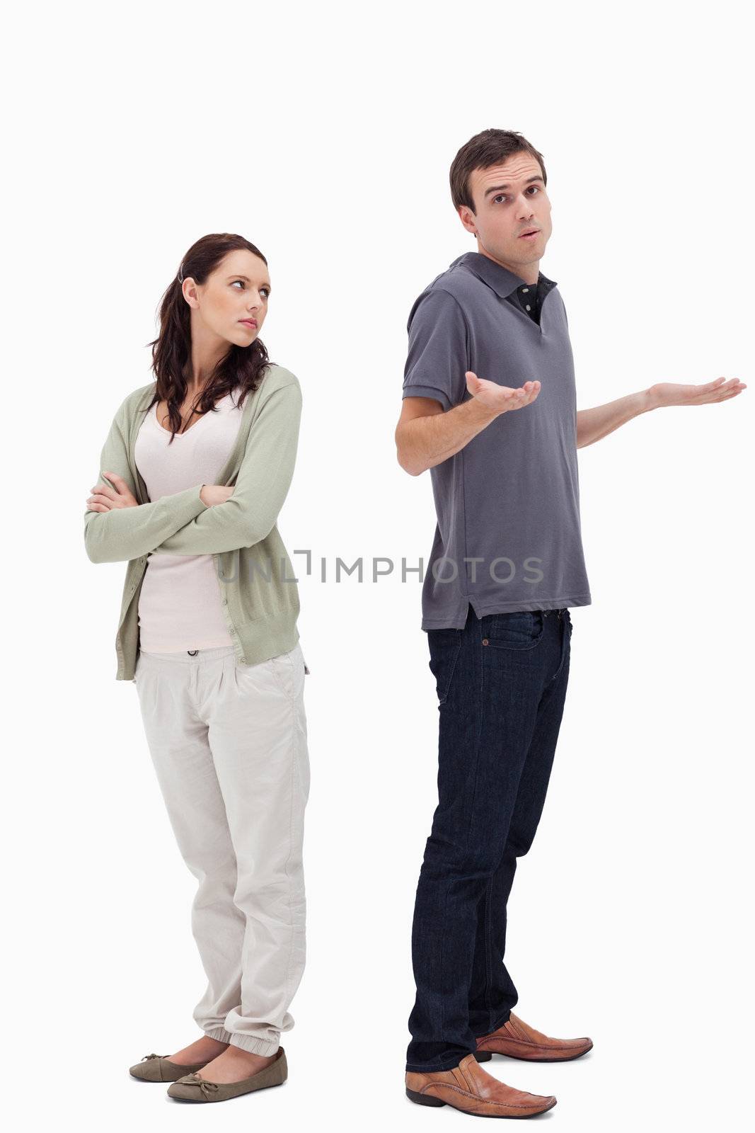 Man shrugged his shoulders back to back with angry woman against white background