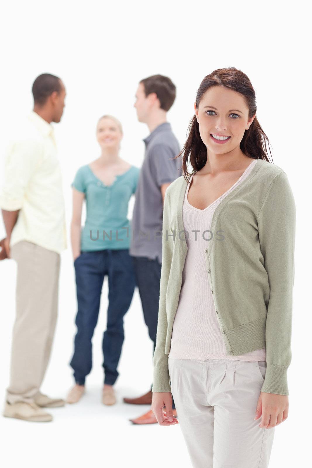 Woman smiling with her friends chatting behind by Wavebreakmedia