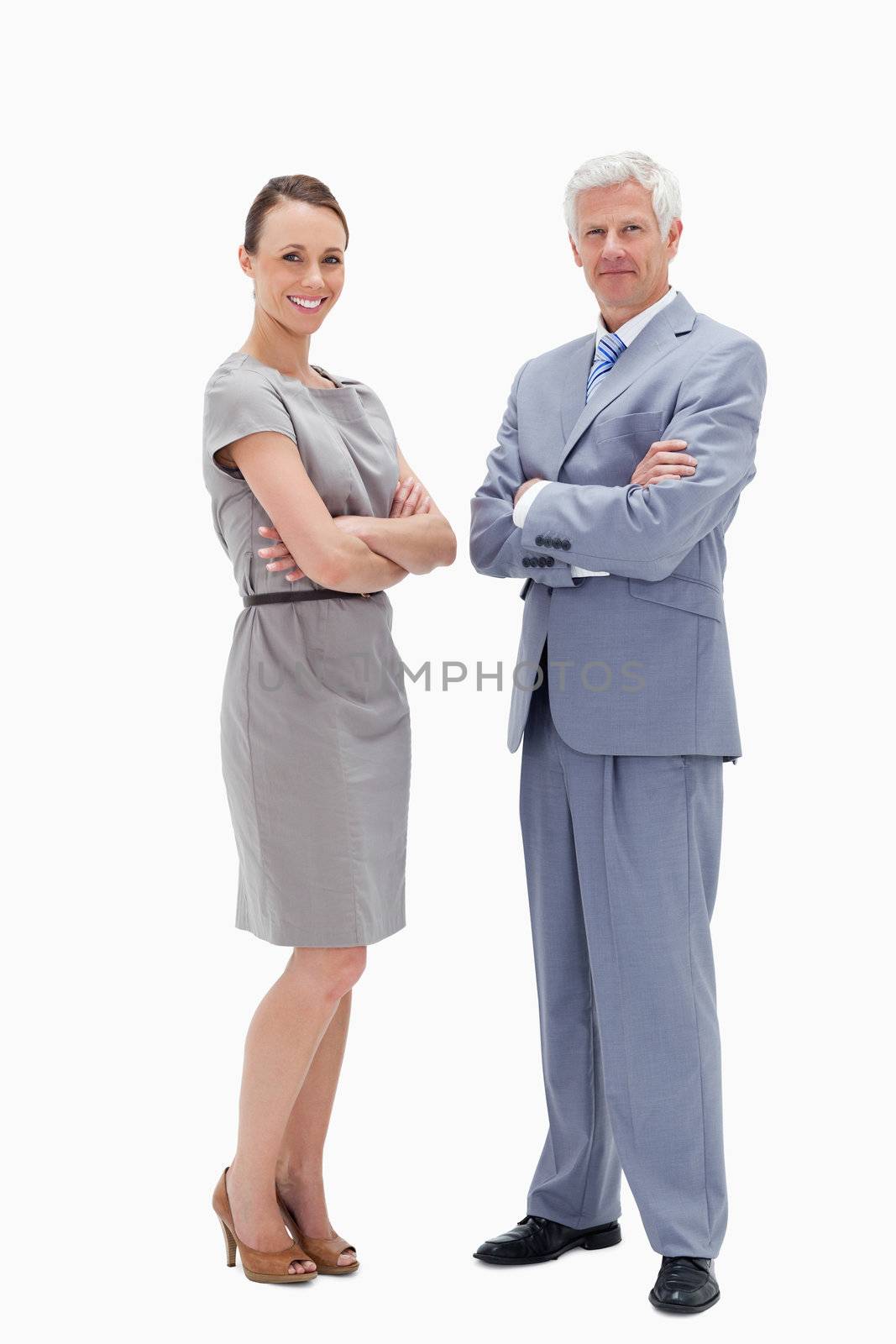 White hair man face to face with a woman crossing their arms and smiling against white background