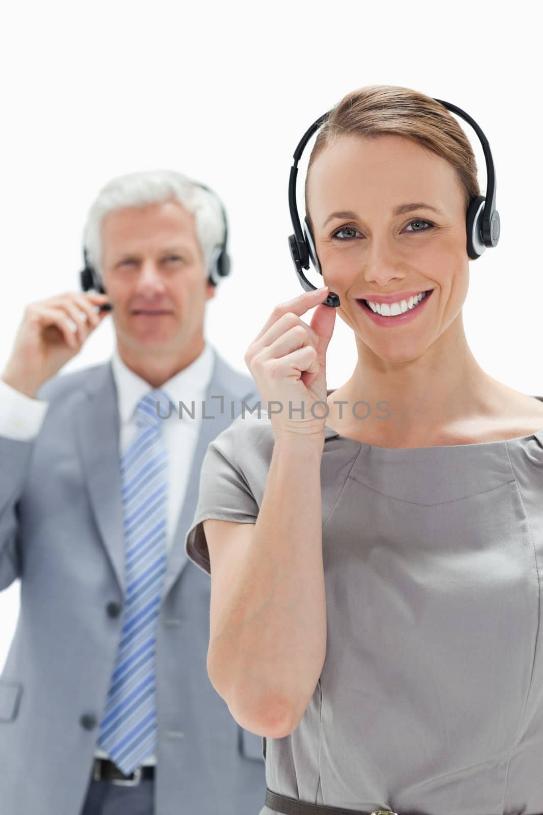 Smiling woman wearing a headset with a  man in background