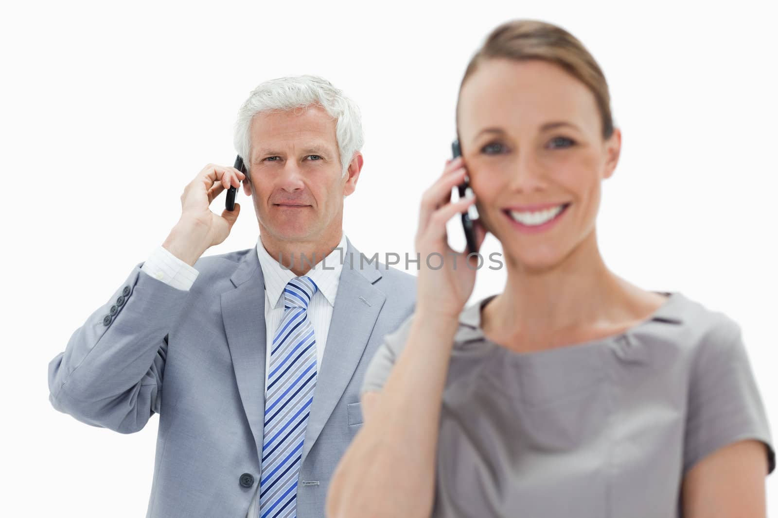 Close-up of a white hair businessman making a call with a smiling woman in foreground against white background