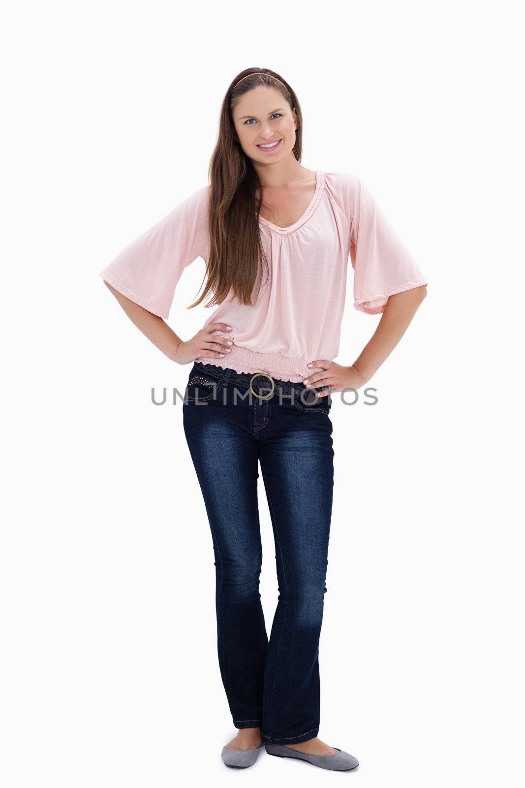 Woman smiling with her hands on the hips against white background