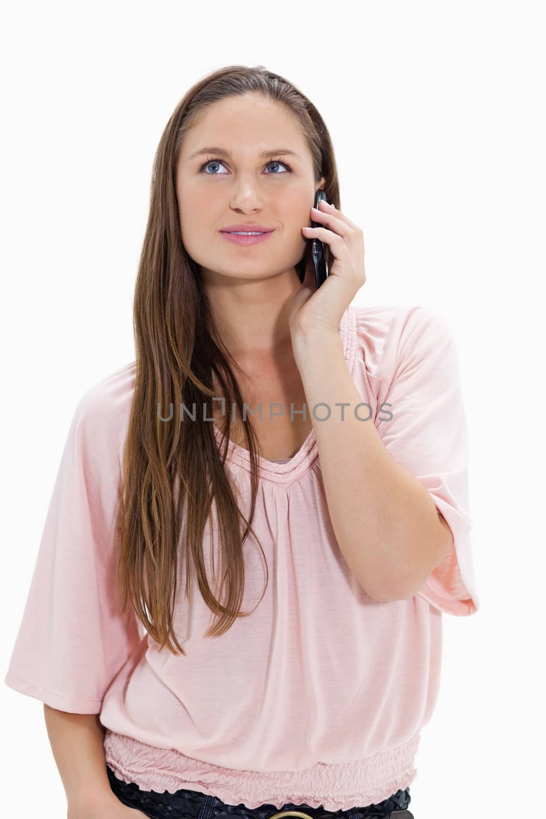 Close-up of a girl listening to a mobile phone against white background