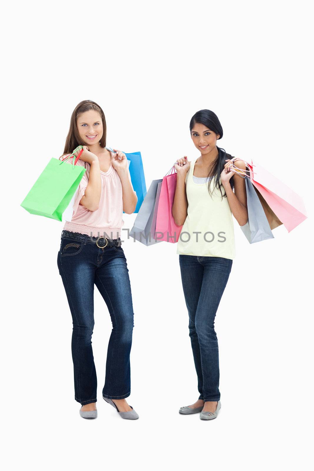 Girls smiling with shopping bags against white background