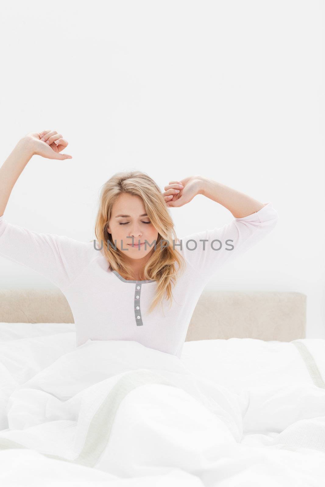 A closer shot of a woman looking forward with her eyes closed and both arms stretched slightly upwards.