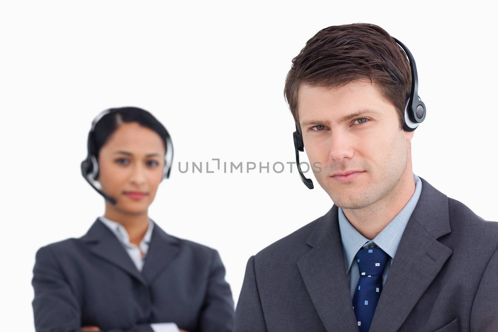 Close up of serious looking call center agents against a white background