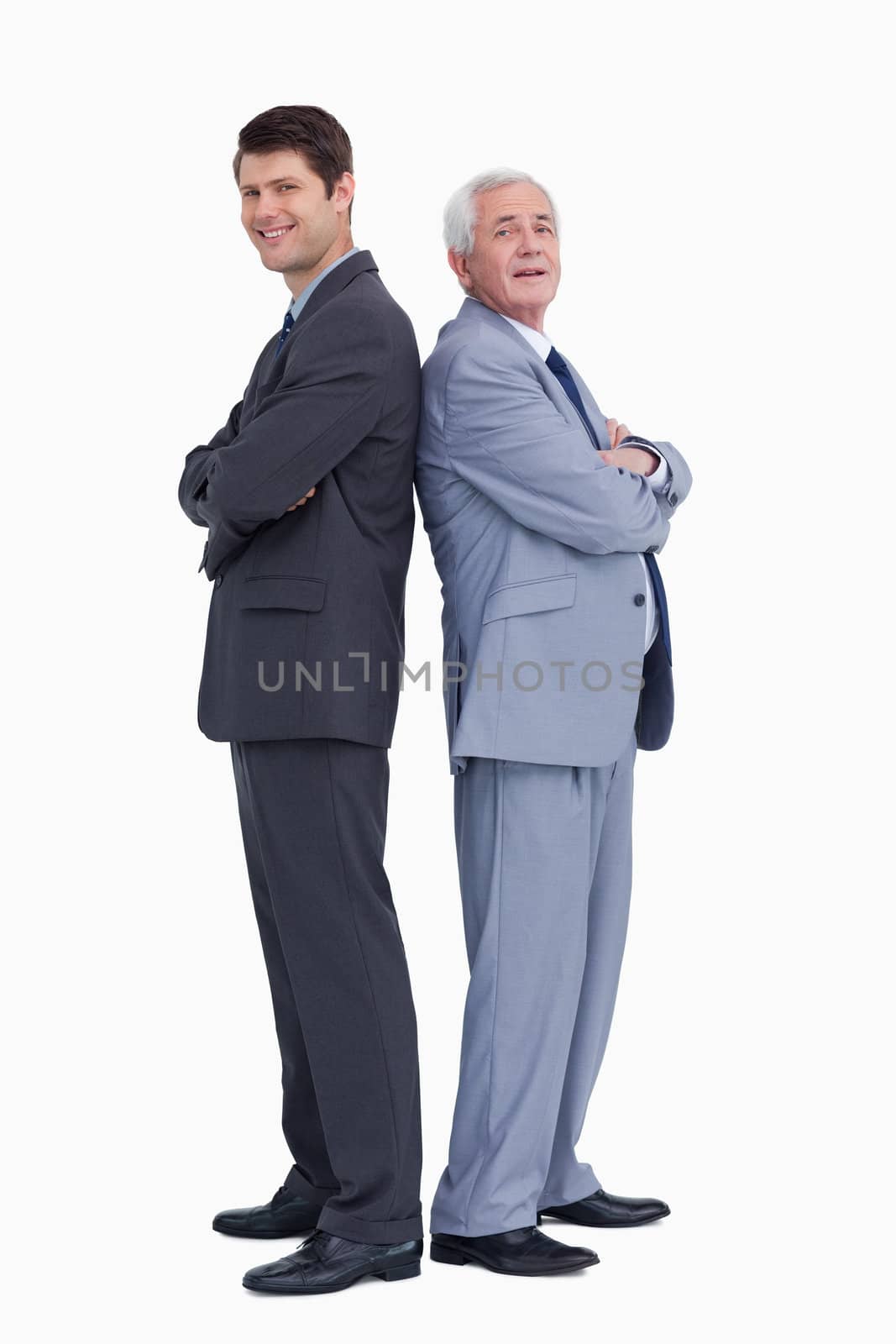 Smiling businessmen standing back to back against a white background