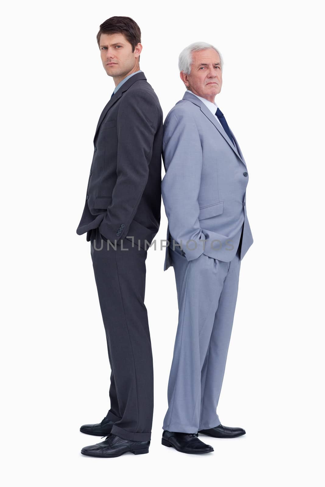 Serious businessmen standing back to back against a white background