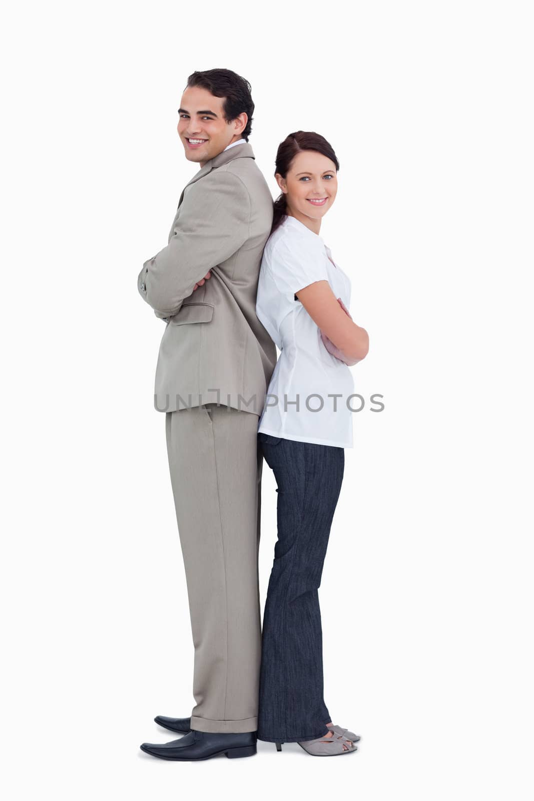 Smiling salesteam standing back to back against a white background