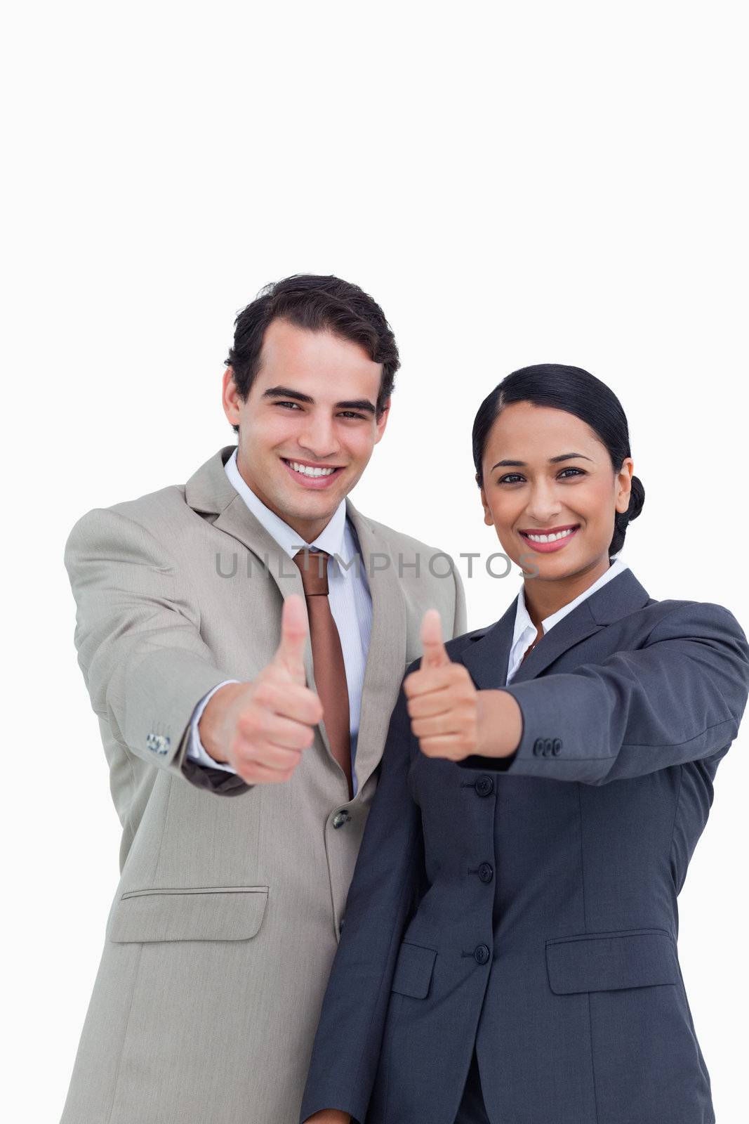 Smiling young salesteam giving thumbs up against a white background