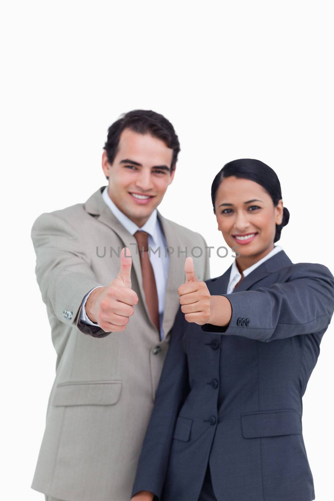 Smiling young salesteam giving their approval against a white background