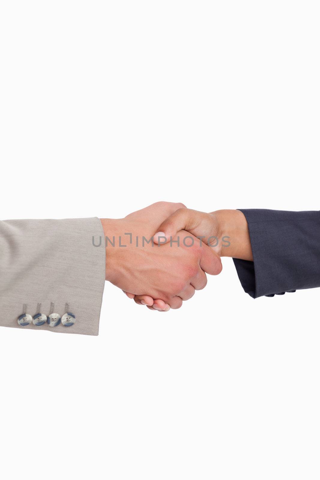 Side view of shaking hands of business people against a white background