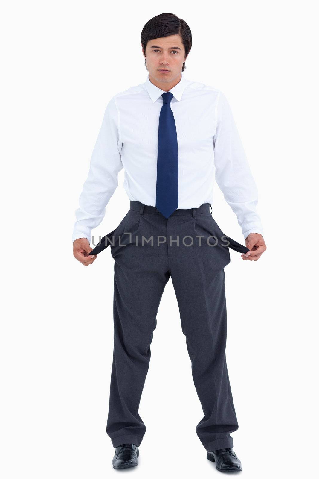Sad tradesman showing his empty pockets against a white background