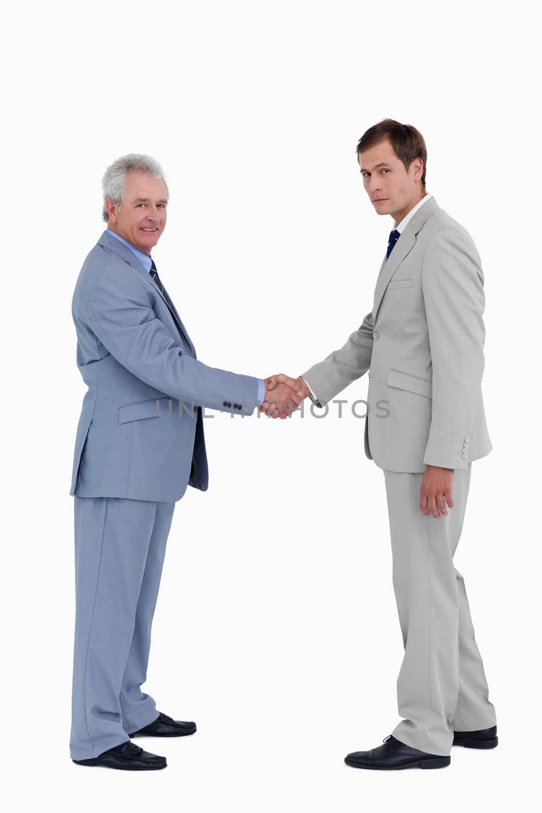 Side view of tradesmen closing a deal against a white background