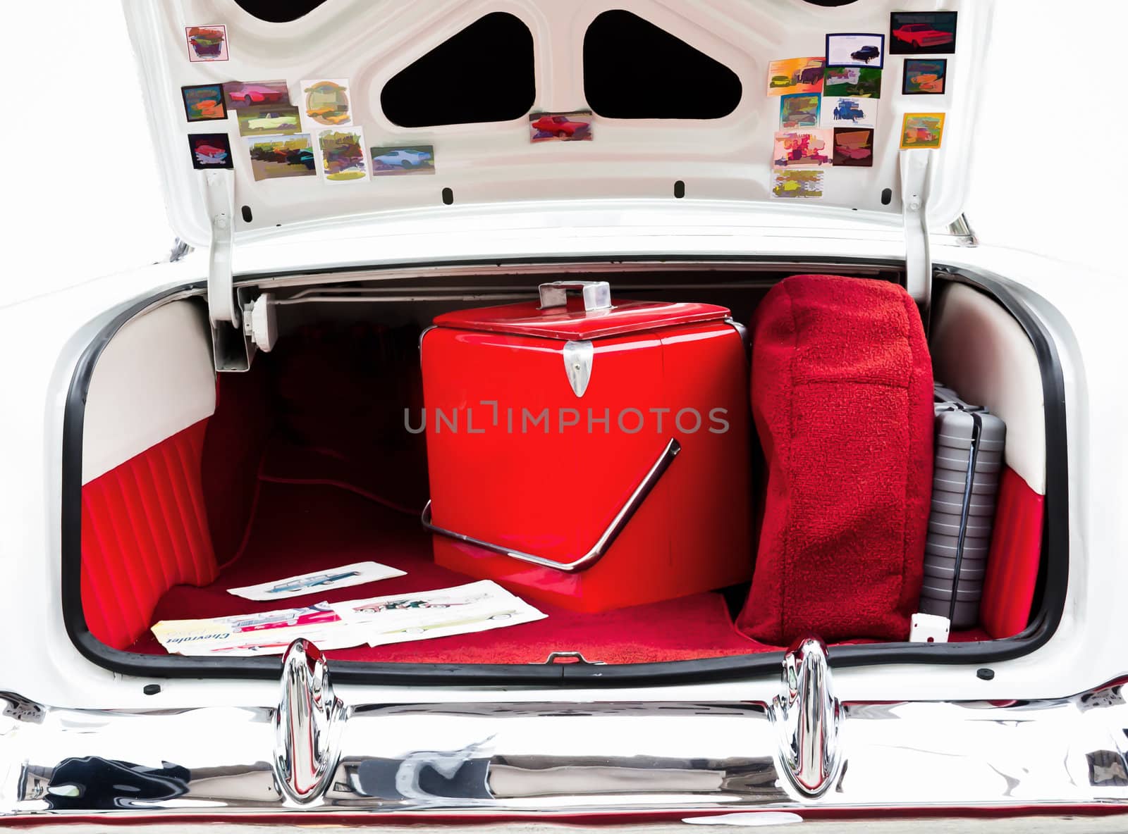 An Open Classic Car Trunk with Red Cooler Inside