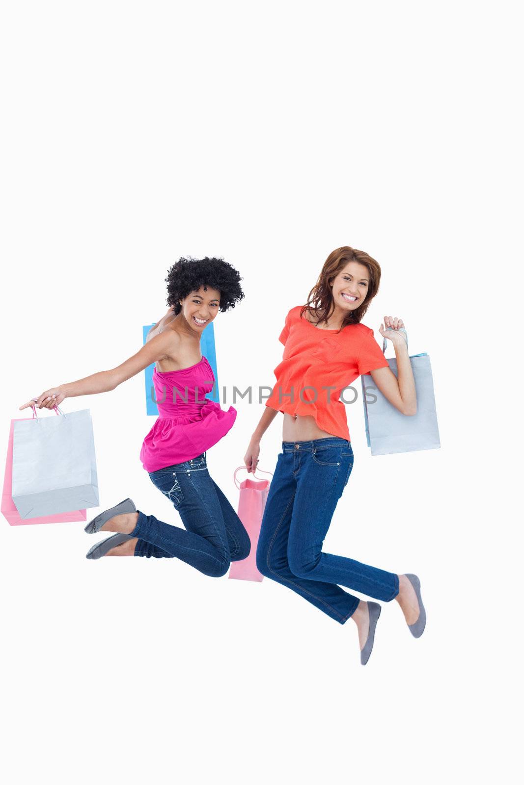 Dynamic teenagers energetically leaping after going shopping