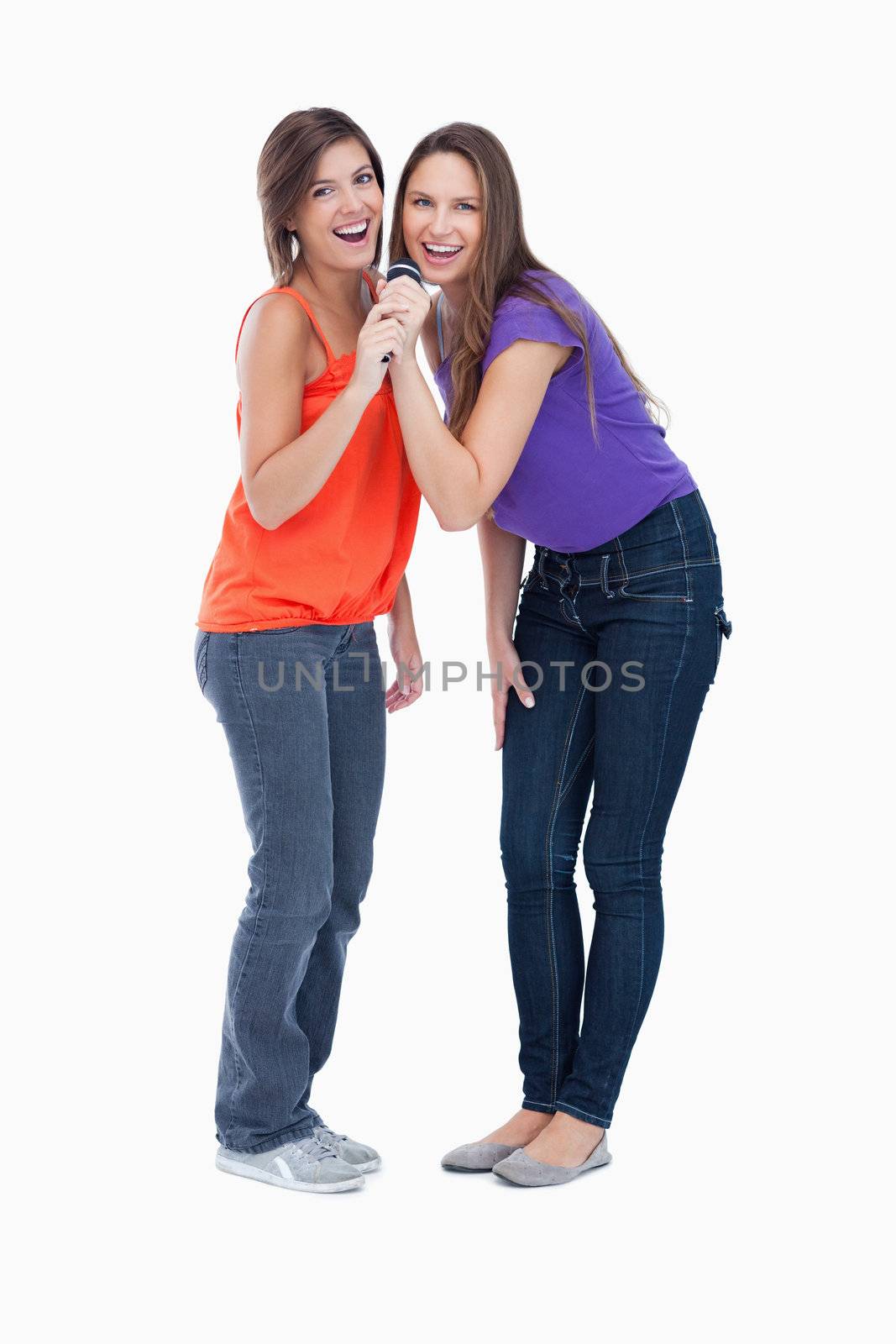 Smiling teenagers singing in a cordless microphone