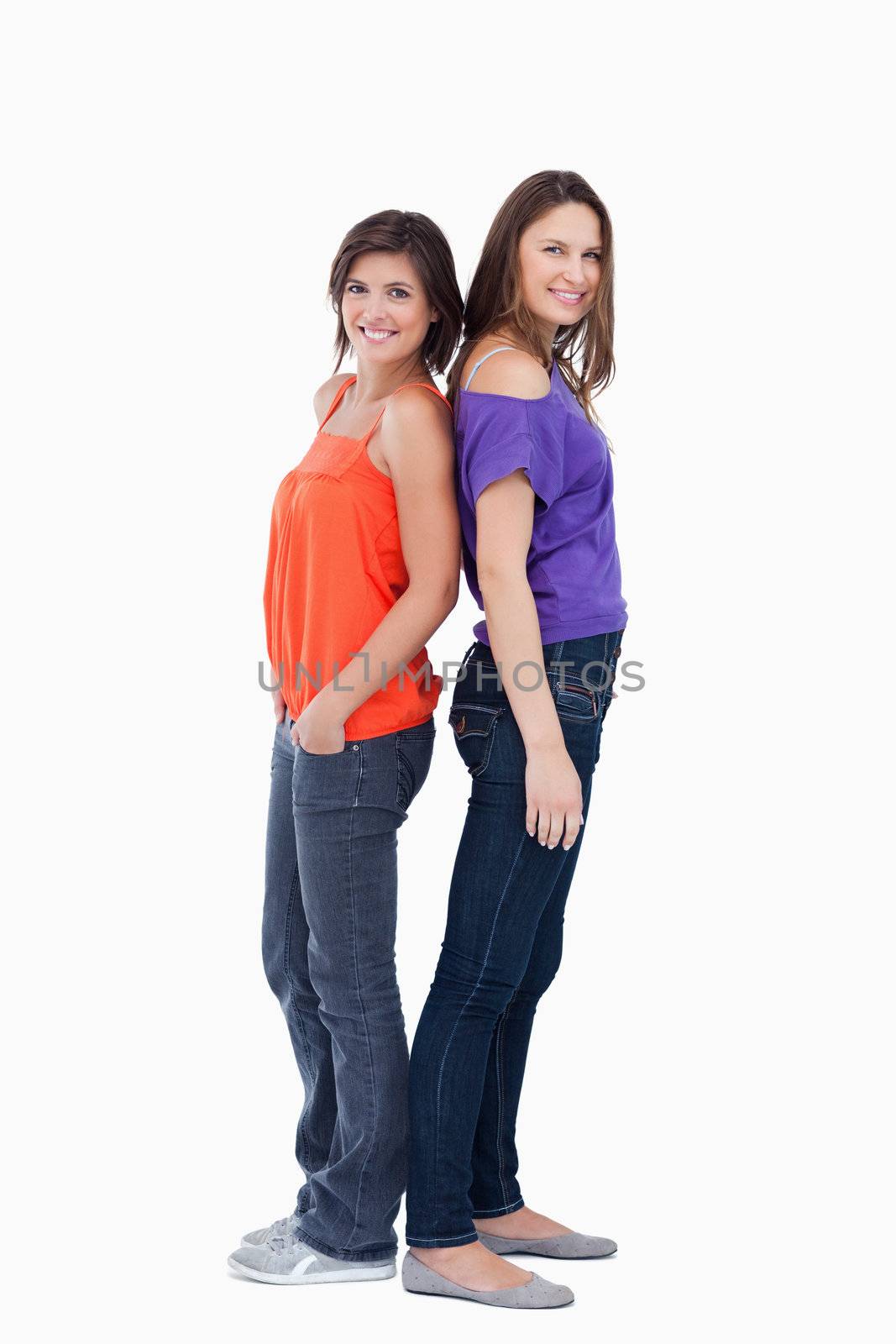 Adolescents standing back to back in front of a white background