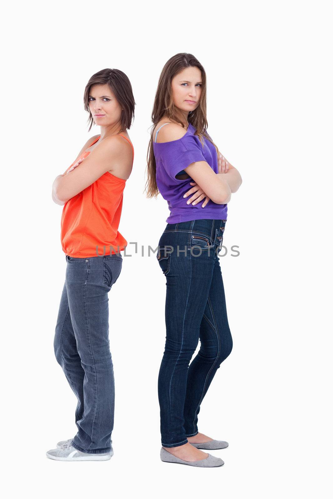 Teenagers standing back to back while wearing casual clothes