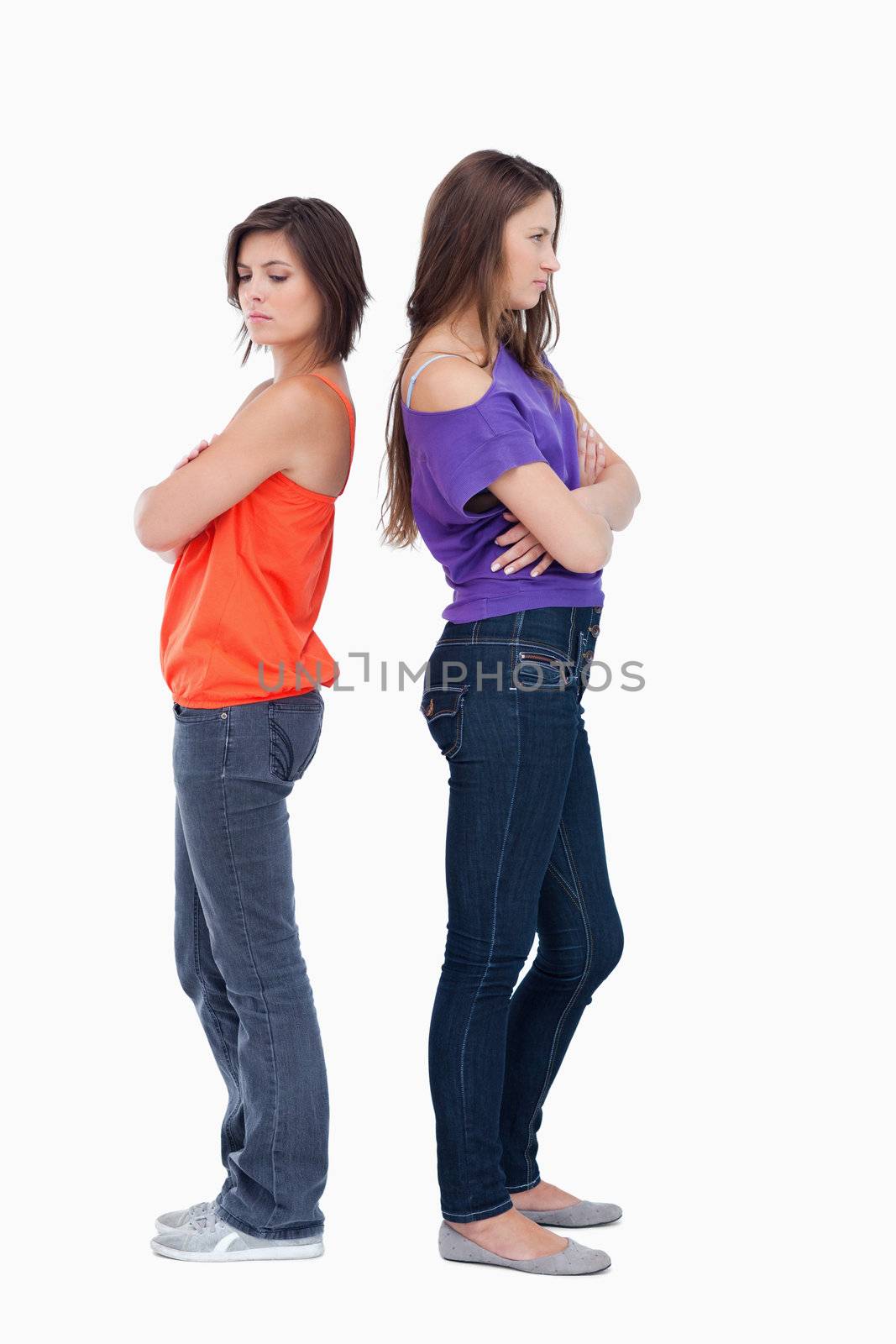 Teenagers standing back to back and crossing their arms