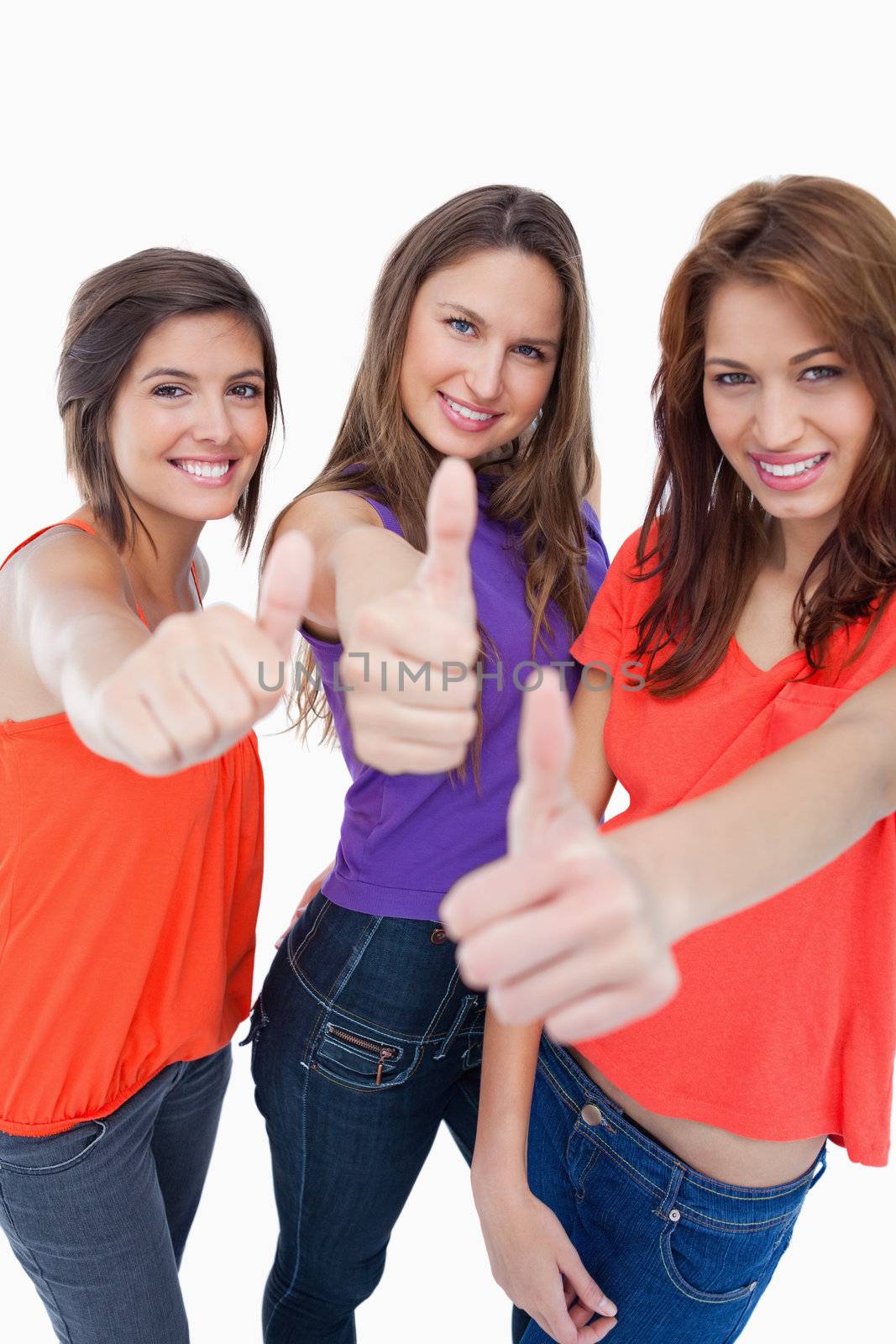 Three teenage girls proudly showing their happiness by putting t by Wavebreakmedia