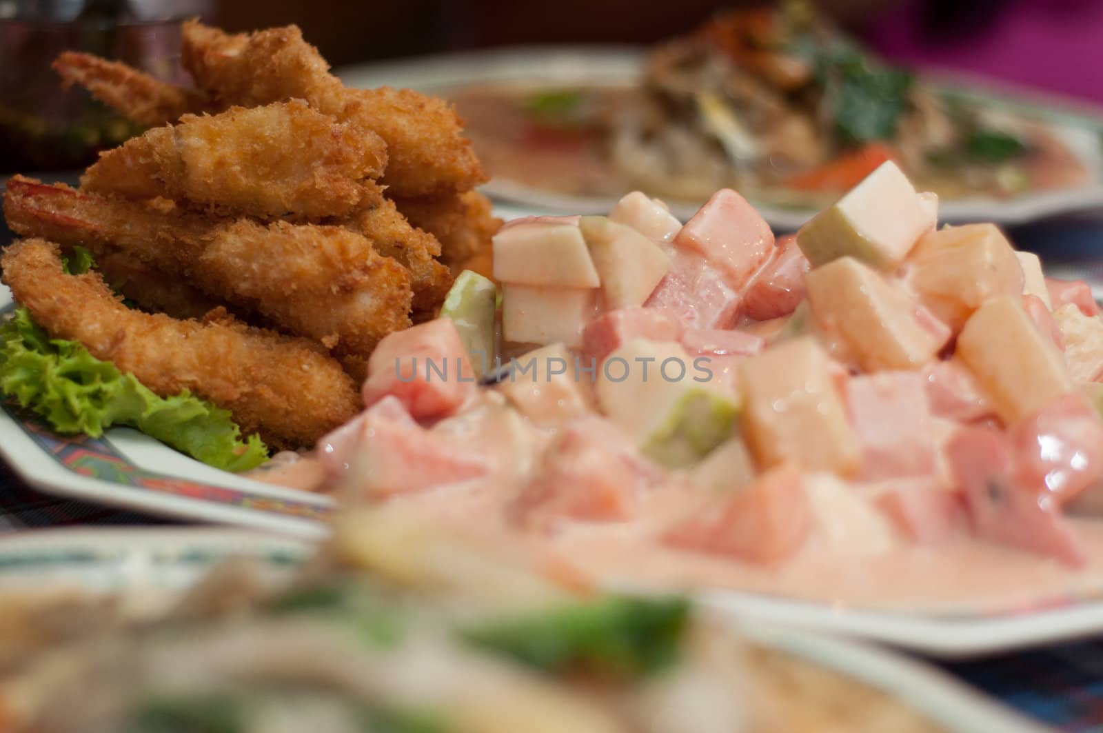 fried shrimp and fruit salad on dishes