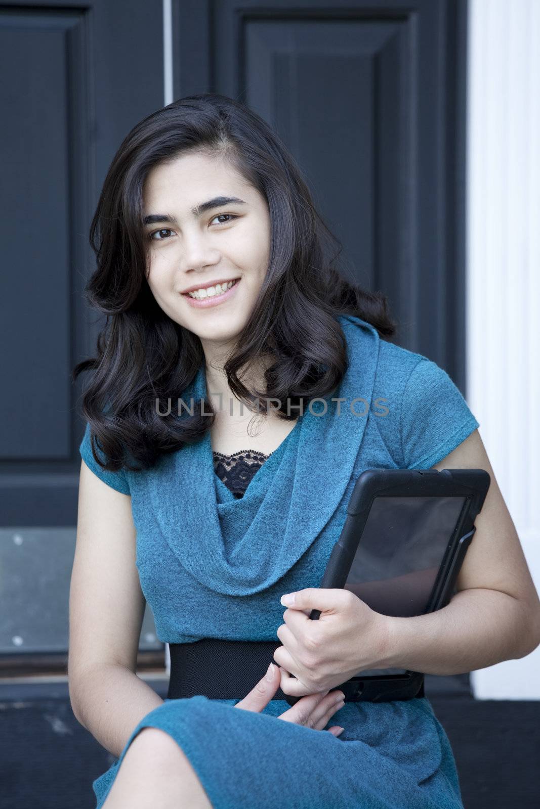 Beautiful, well dressed, biracial teen or young woman holding computer tablet