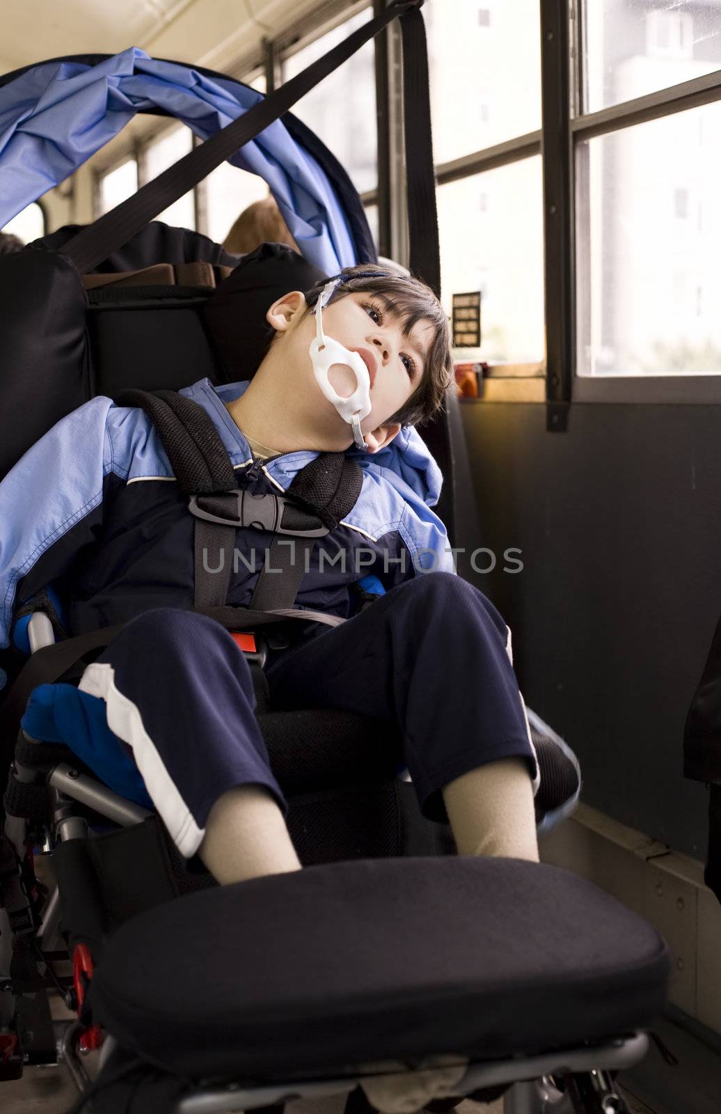 Disabled little boy sitting in wheelchair on school bus by jarenwicklund