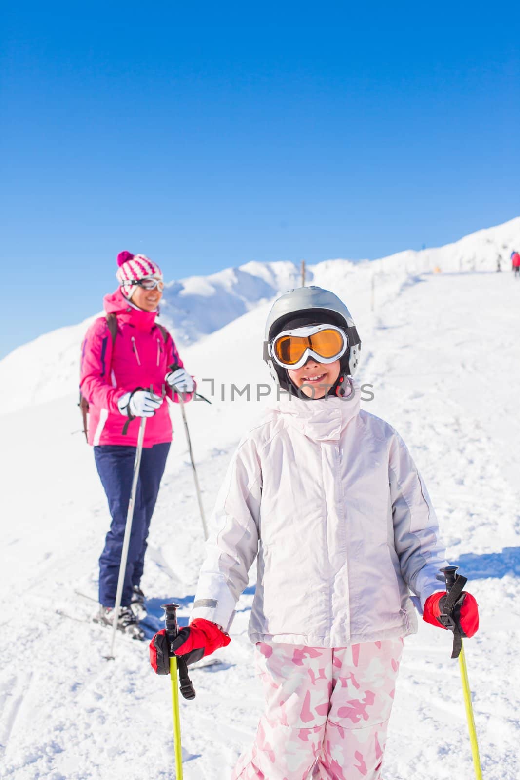 Happy smiling girl in ski goggles and with her mother, Zellertal, Austria