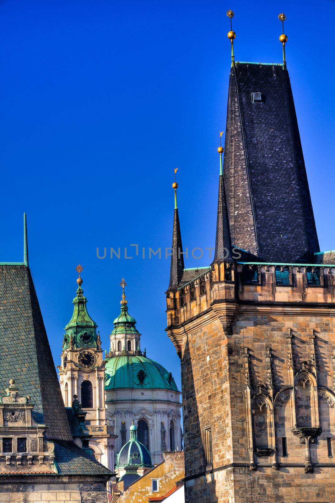 Famous church at one end of Charles bridge on the river in Prague.