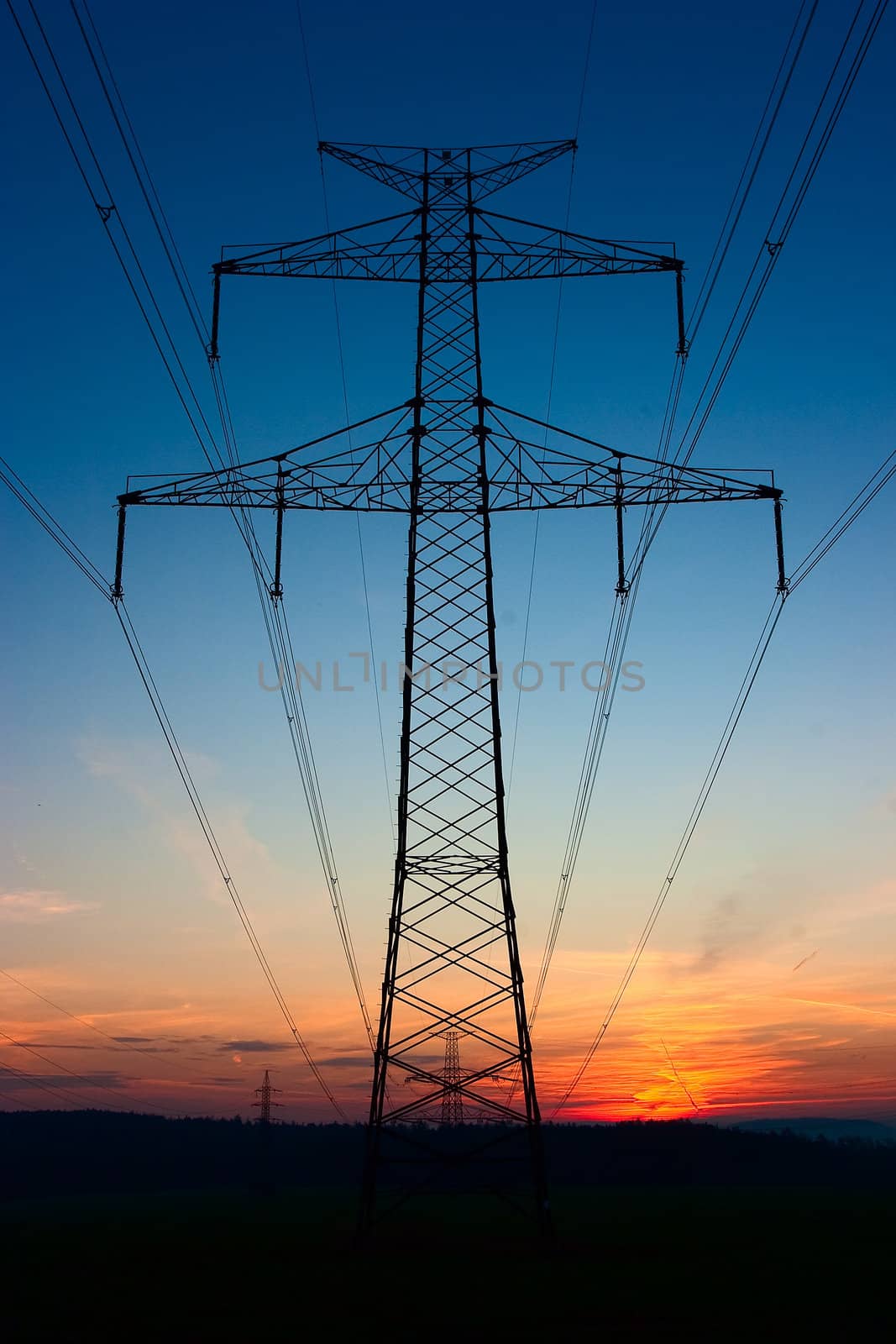 Transmission towers on the hills at red sunset