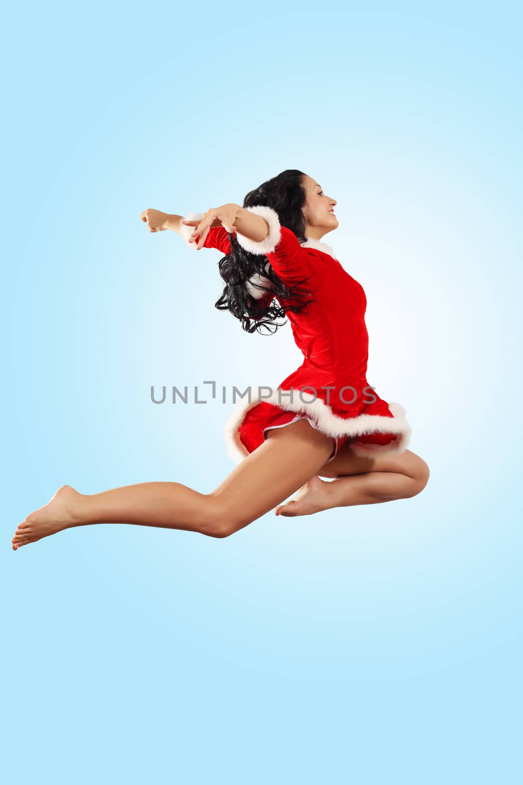 Happy smiling woman in red xmas costume jumping high