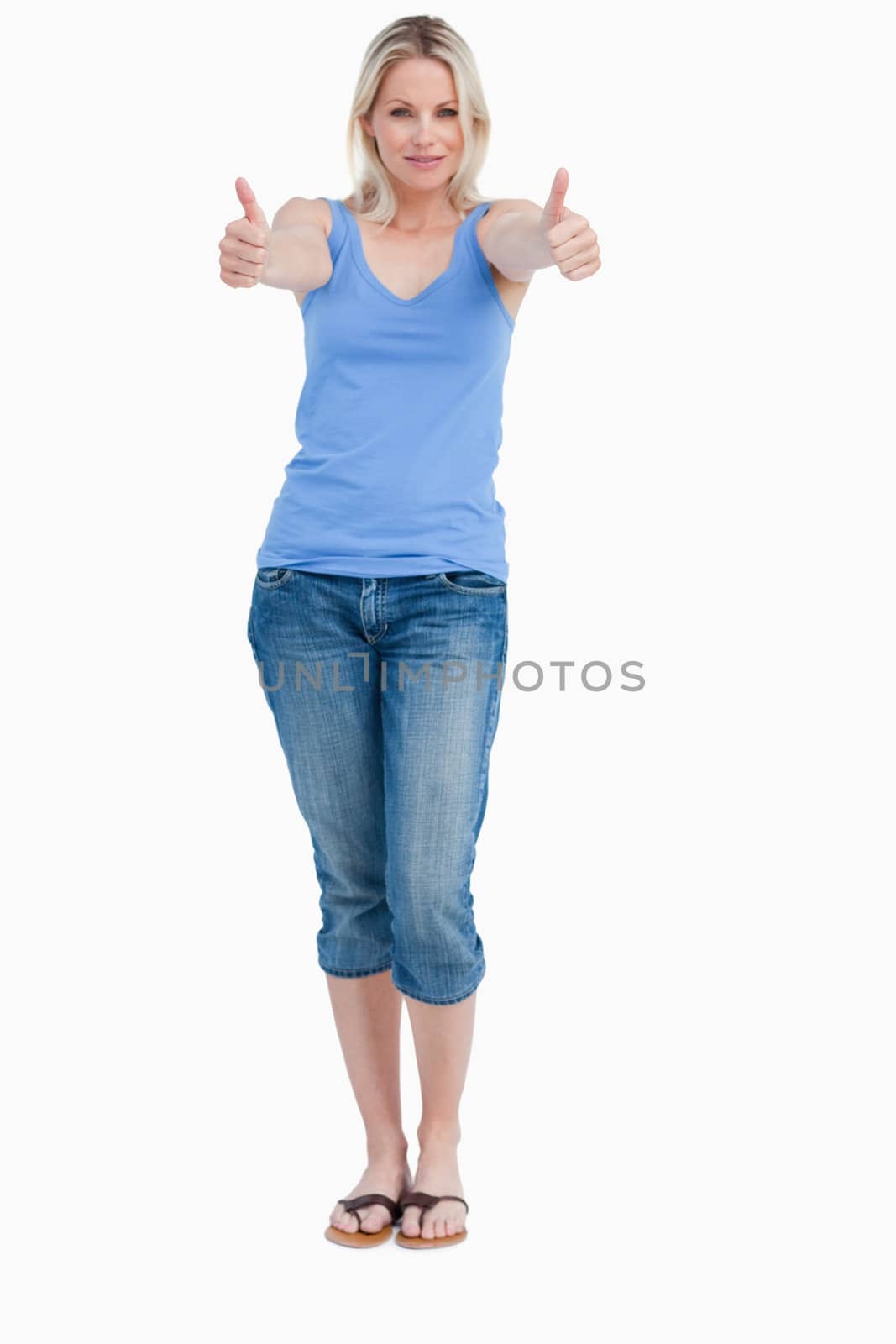Blonde woman standing upright with her thumbs up against a white background