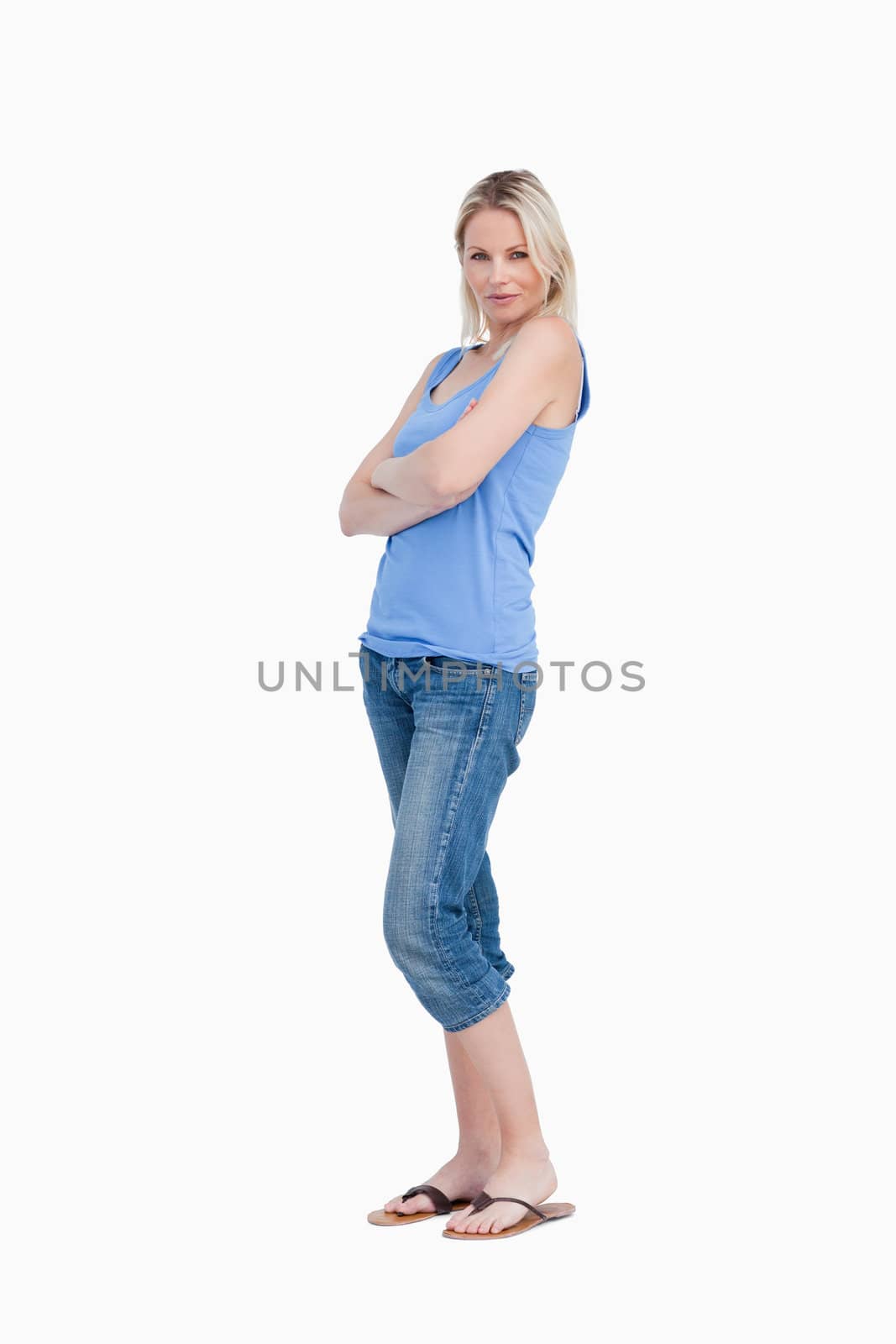 Young woman standing up and crossing her arms against a white background