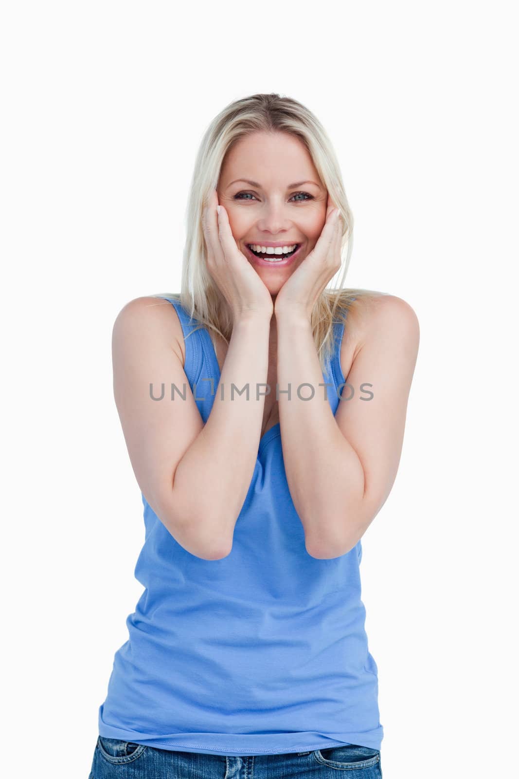 Happily surprised blonde woman putting her hands on cheeks