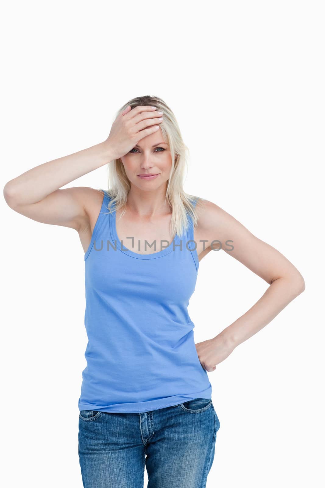 Blonde woman placing her hand on her forehead against a white background