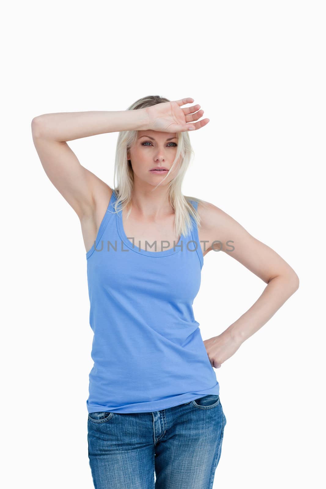 Sad blonde woman putting her hand on forehead against a white background