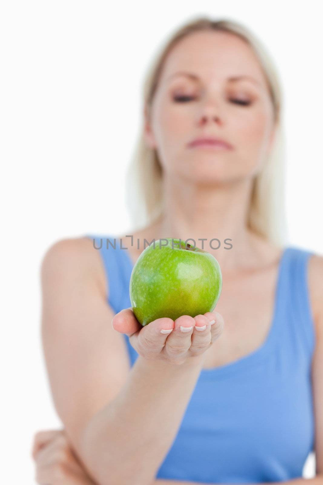 Beautiful green apple held by a blonde woman against a white background