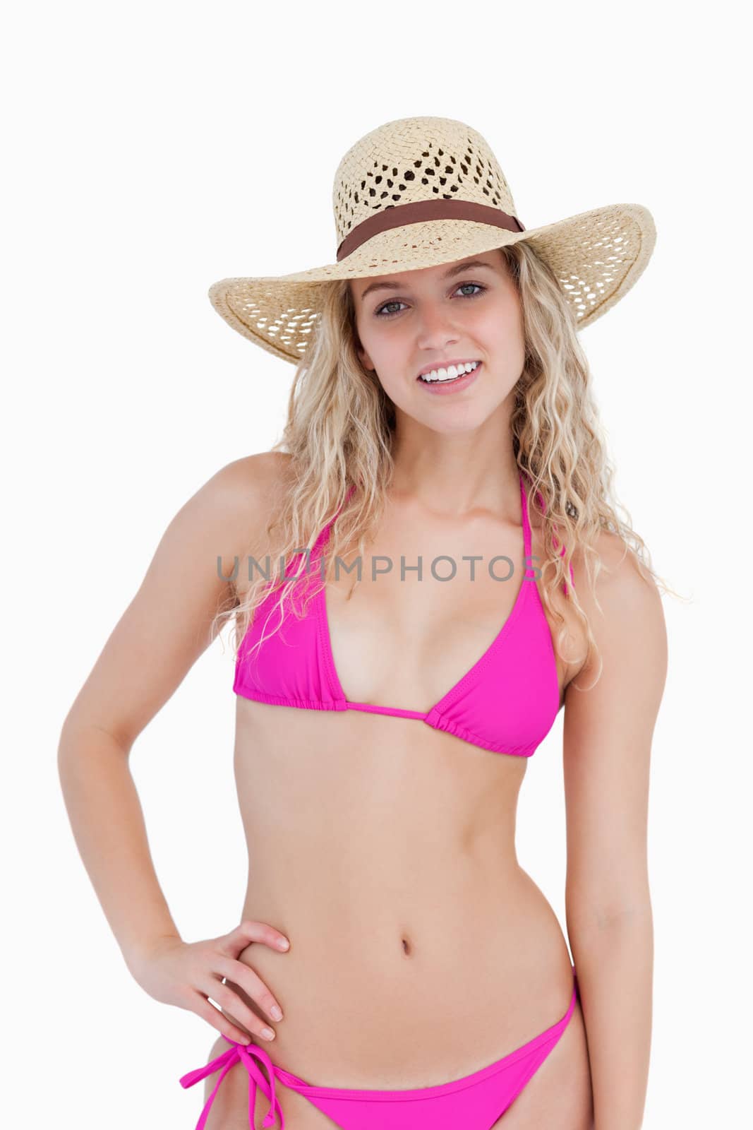 Attractive blonde teenager placing a hand on her hip against a white background