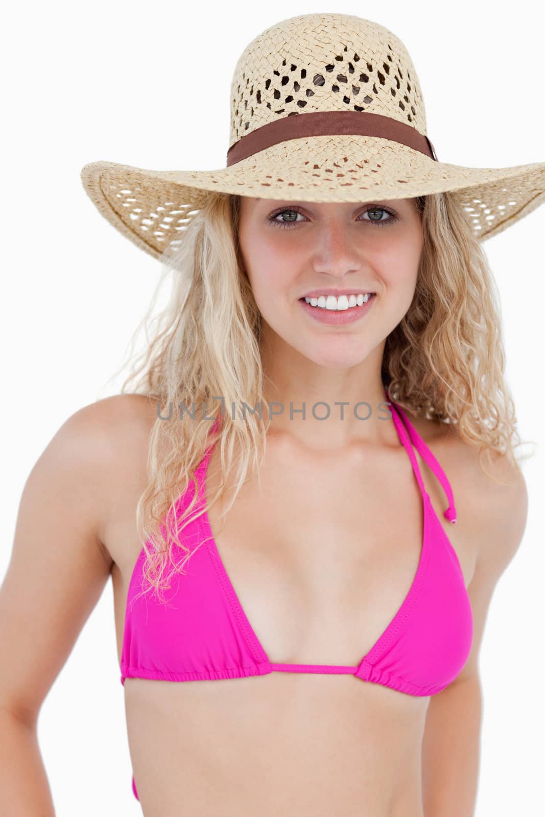 Smiling attractive teenager in beachwear standing upright against a white background