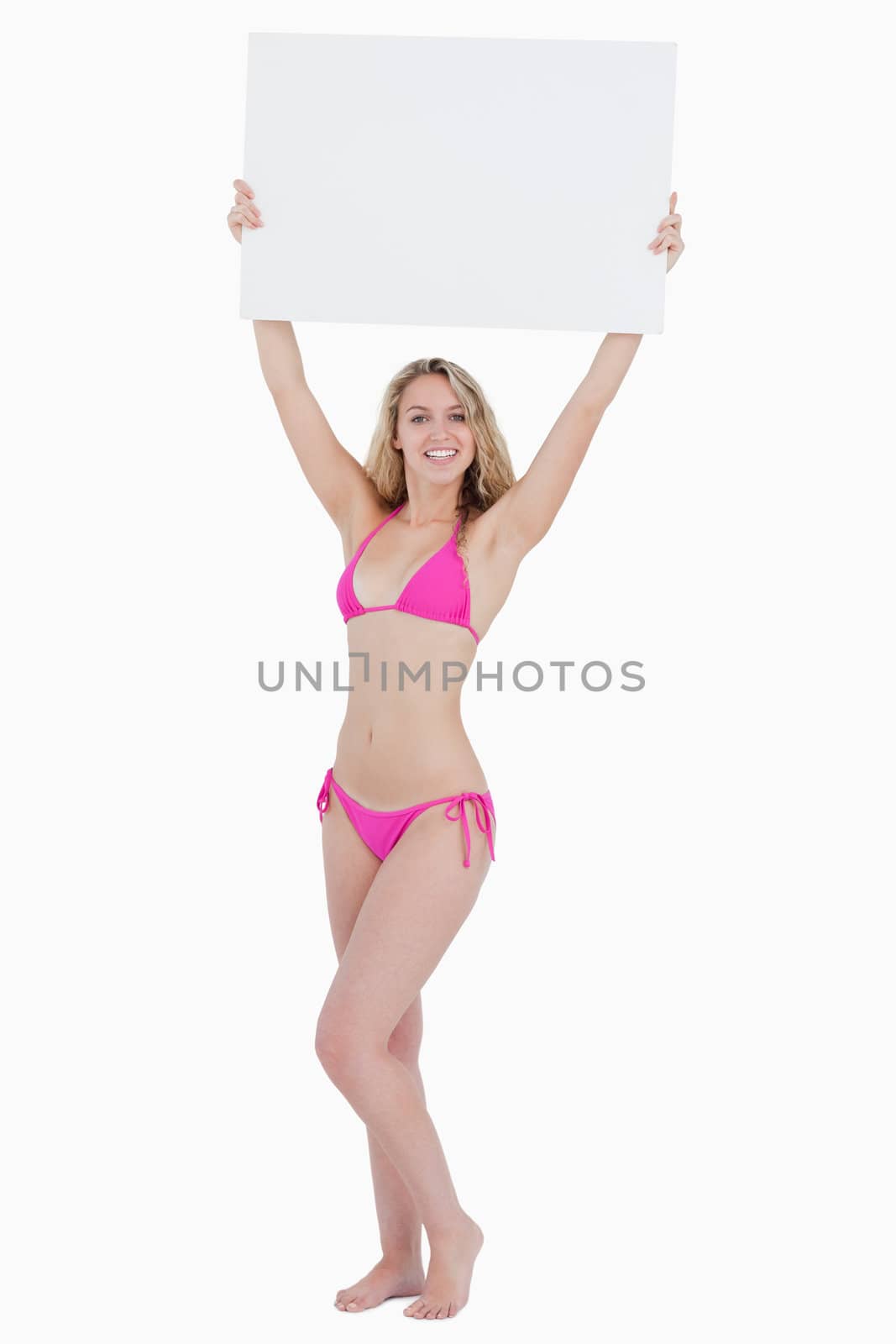 Young woman raising a blank poster above her head against a white background