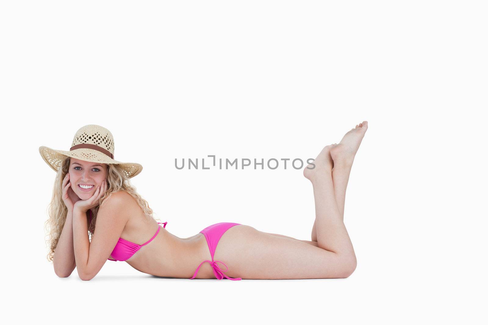 Young attractive woman lying down with her legs crossed against a white background