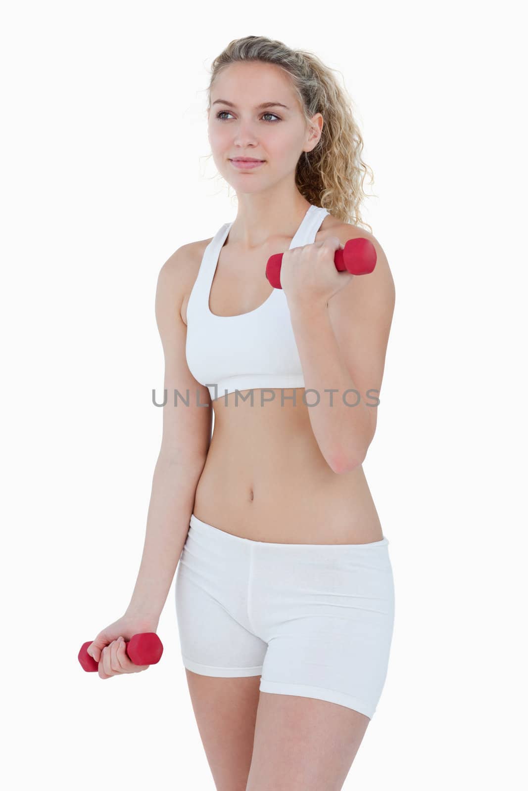 Teenager looking to the side while lifting weights against a white background