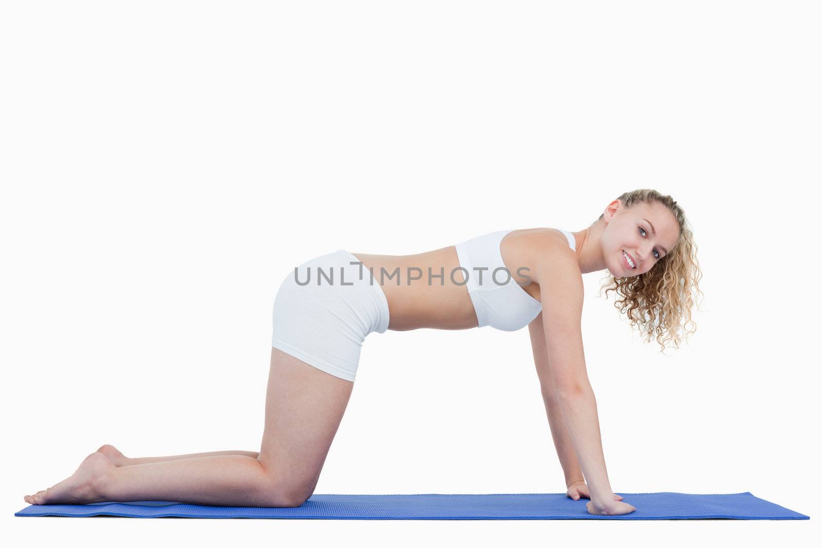 Side view of a teenage doing gymnastics on all fours against a white background