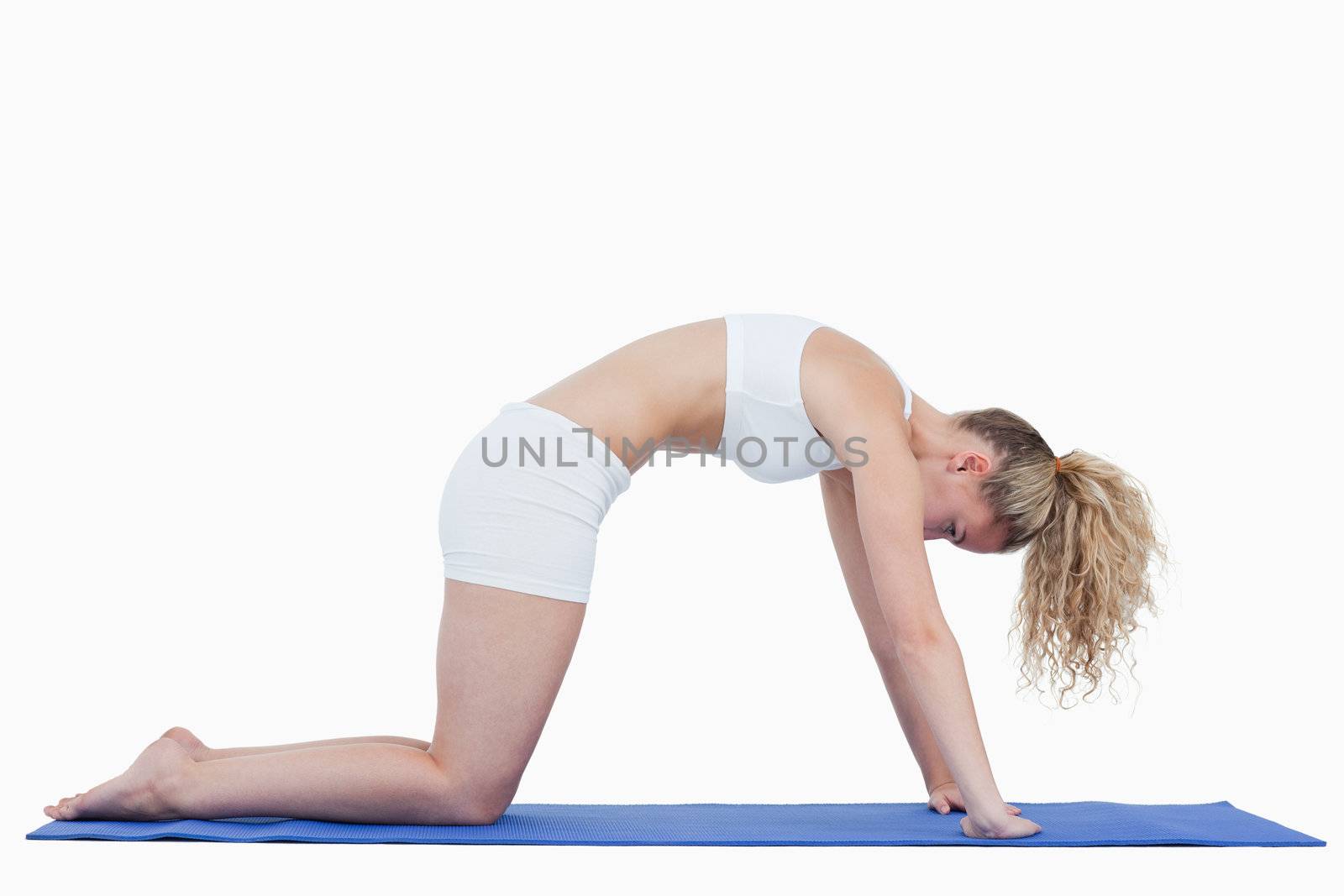 Young woman in sportswear doing gymnastics against a white background